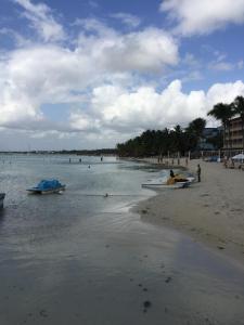a beach with boats and people in the water at Terraza del Caribe in Boca Chica