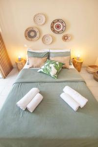 a large green bed with two pillows on it at Puerto Seaside Rooms in Akhladherí