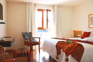 1 dormitorio con 2 camas, escritorio y silla en San Agustin Plaza, en Cusco