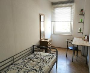 a bedroom with a bed and a table and a mirror at Privatzimmer Fürth Zentrum in Fürth