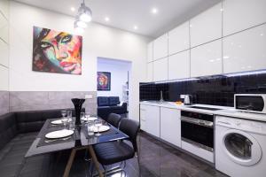 a kitchen with a table and a washing machine at Arkadia Palace Luxury Apartments in Odesa