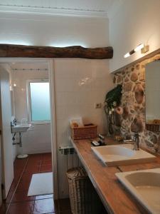 een badkamer met een wastafel en een spiegel bij Vila Delfina in Lousã