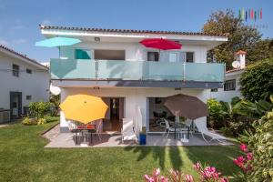 a house with three umbrellas in the yard at CasaColores Apartamentos in Puerto de la Cruz