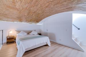 um quarto com uma cama e um tecto em madeira em DREAM OF LOFT em Olhão