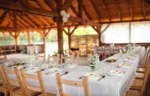 a long white table with chairs and plates of food at Domki na łowisku Admar w Dąbiu Lubuskim in Dąbie