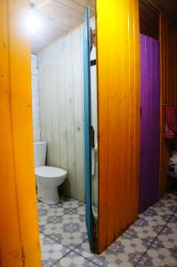 a bathroom with a toilet and a door open at Pousada Pico da Galera/Maquiné in Barra do Ouro