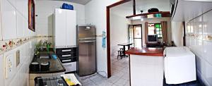 a kitchen with a refrigerator and a table in it at Casa Cabo Frio - Ogiva in Cabo Frio