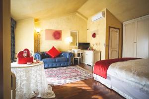 a bedroom with a bed and a couch and a table at Hotel Posta in Cecina