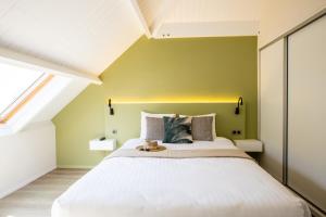 a bedroom with a large bed with a yellow wall at Centr'Hotel in Marigot