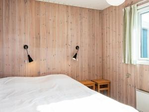 6 person holiday home in B rkop في Børkop: غرفة نوم بجدران خشبية مع سرير وإضاءتين