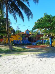 una casa amarilla en la playa con palmeras en Livingston Resort Hotel en Lívingston