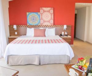 a bedroom with a large bed with a red wall at Sunscape Puerto Vallarta Resort in Puerto Vallarta