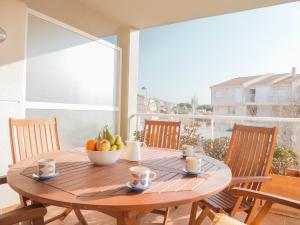 una mesa de madera con un bol de fruta en el balcón en Marineu Alcocebre Apartamentos Serena Mar, en Alcossebre