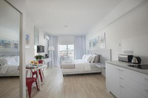 a white living room with a bed and a table at Kitieos Apartments in Larnaca