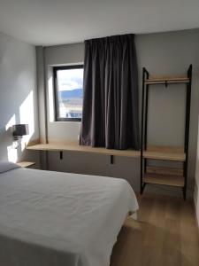 um quarto com uma cama e uma janela em Los Rosales em Almázcara