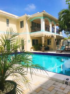 a large house with a swimming pool in front of it at Beach Aqualina Apartments in Fort Lauderdale