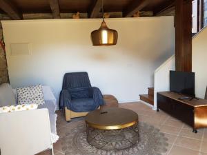 Una sala de estar con un sofá, una mesa y un televisor. en PALLERO BAIXO, en Las Colladas