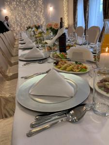 una mesa con platos de comida en un mantel blanco en Hotel Dworek***, en Skierniewice