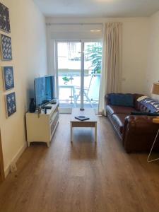 a living room with a couch and a tv at Apartment Los Boliches Fuengirola Malaga Spain in Fuengirola
