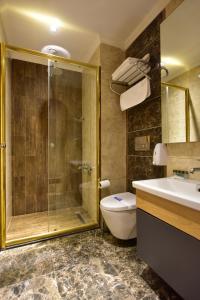 a bathroom with a shower and a toilet and a sink at Inanlar Garden Hotel & Bungalow in Uzungol