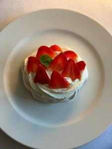 un pastel con fresas en un plato blanco en Hotel Dworek***, en Skierniewice