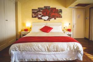 a bedroom with a large bed with a red pillow at Hotel Posta in Cecina