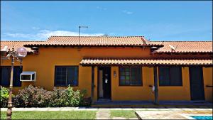 una casa amarilla con techo en Casa Cabo Frio - Ogiva, en Cabo Frío