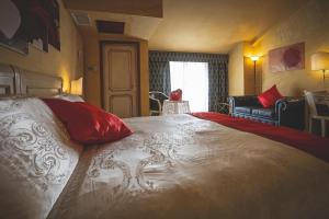 a bedroom with a large bed with red pillows at Hotel Posta in Cecina
