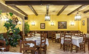 a restaurant with tables and chairs in a room with yellow walls at Zumaia Hotela in Zumaia