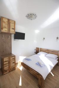 新瓦羅許的住宿－Vila PARADIZO-ZLATAR, studio apartman 1，卧室配有一张床,墙上配有电视。