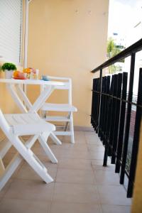 uma mesa branca e cadeiras numa varanda em MONKÓ - ROSARIO APARTMENT BEACH & SUN o em Torremolinos