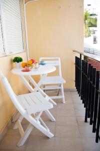 uma mesa branca e cadeiras numa varanda em MONKÓ - ROSARIO APARTMENT BEACH & SUN o em Torremolinos
