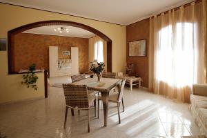 a living room with a table and chairs and a mirror at B&B Le Tre rose dell'Etna in Zafferana Etnea