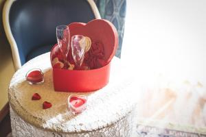a red heart box with wine glasses on a table at Hotel Posta in Cecina
