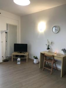 a living room with a tv and a table and a desk at GiorGiada Relax in Castelmola