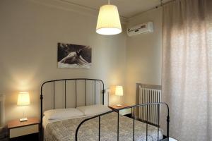 1 dormitorio con 1 cama, 2 mesas y 1 lámpara en B&B Cameracaffè Centro, en Arezzo