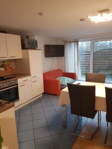 eine Küche und ein Wohnzimmer mit einem Tisch und einem Sofa in der Unterkunft Ferienwohnung Ulmrich in Kesselbach