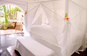a white bed with a canopy in a room at Sugar Beach, A Viceroy Resort in Soufri&egrave;re