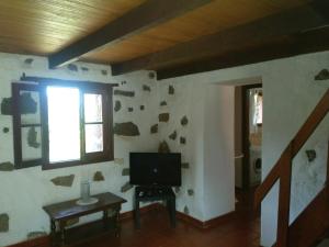 sala de estar con TV en la pared en Casa Rural Higuera Morales, en Mocanal