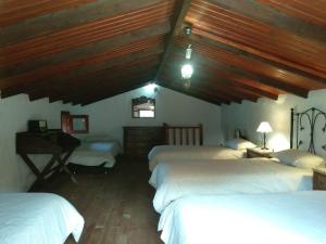 Un dormitorio con 3 camas y un escritorio en una habitación en Casa Rural Higuera Morales, en Mocanal