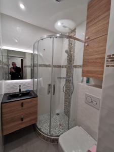 La salle de bains est pourvue d'une douche et d'un homme dans le miroir. dans l'établissement Les pieds dans l'eau, à Trouville-sur-Mer
