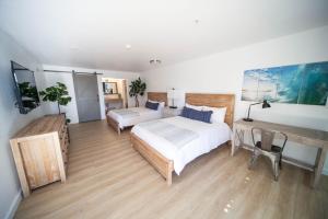 - une chambre avec un grand lit et un bureau dans l'établissement The Surfbreak Hotel, à San Clemente