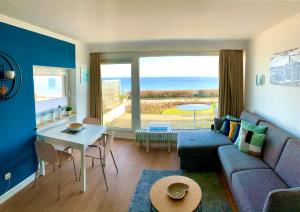 ein Wohnzimmer mit einem Sofa und einem Tisch in der Unterkunft Meerblick Riviera 140 in Scharbeutz