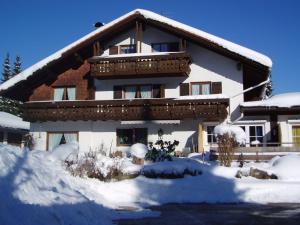 a house with snow on the ground in front of it at Gästehaus Christa in Obermaiselstein