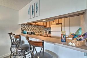 una cucina con sgabelli da bar e piano di lavoro di Kailua-Kona Condo with Lanai, Walk to Beach and Pier! a Kailua-Kona
