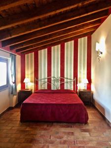 a bedroom with a bed with red and white stripes at Villa Redona in Entratico