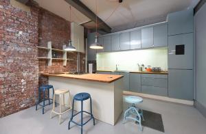 una cucina con armadi blu e sgabelli blu di Mason Street Apartment Sleeps 16 a Manchester