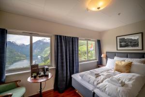 1 dormitorio con cama y ventana grande en Hotel Utsikten - by Classic Norway Hotels, en Geiranger