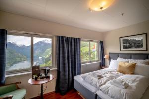 um quarto com uma cama e uma grande janela em Hotel Utsikten - by Classic Norway Hotels em Geiranger