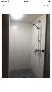 a bathroom with a shower with white tiles at Puutaloasunto 1 km Turun Aurajoelta föriltä in Turku